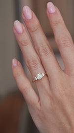 A video of the cushion-cut diamond engagement ring worn on a finger, capturing its sparkle and delicate yellow gold setting.