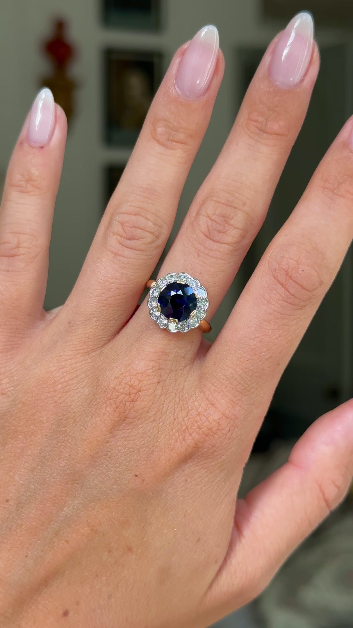 belle epoque sapphire and diamond cluster ring, worn on hand and moved away from lens to give perspective,front view.