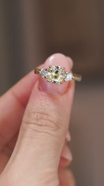 A close-up video of the old-mine diamond ring balanced on a fingertip.