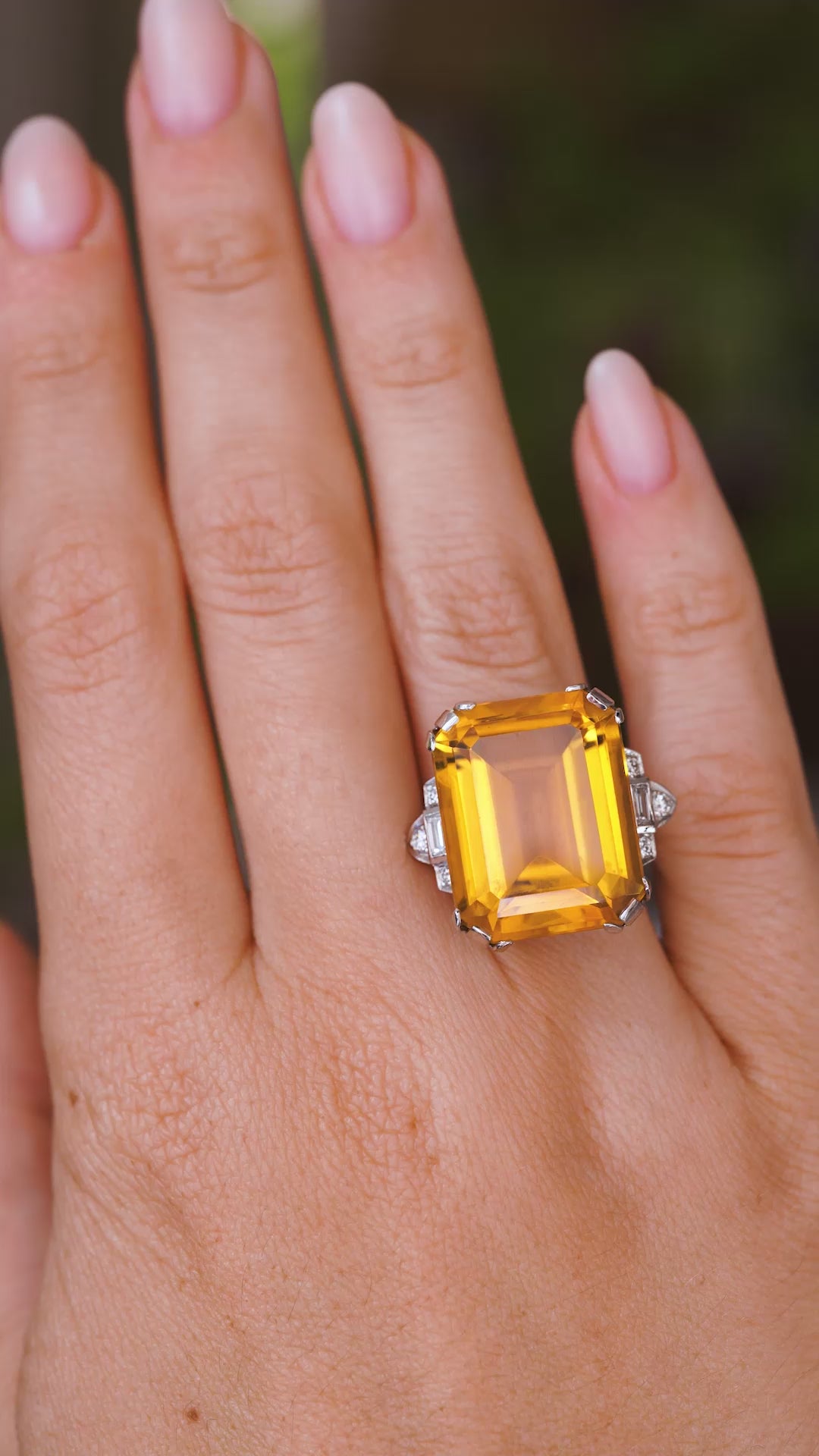 A video of an Antique, Art Deco citrine and diamond cocktail ring in platinum worn on a hand as it slowly moves.