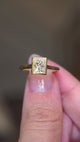 Video of a Vintage-inspired, princess-cut diamond rub-over solitaire engagement ring in yellow gold, held between two fingers and rotated to see all angles.