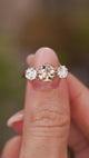 A video of an Antique, Edwardian brown diamond trilogy engagement ring eld between the fingers and rotated to show off the yellow gold band and platinum settings.