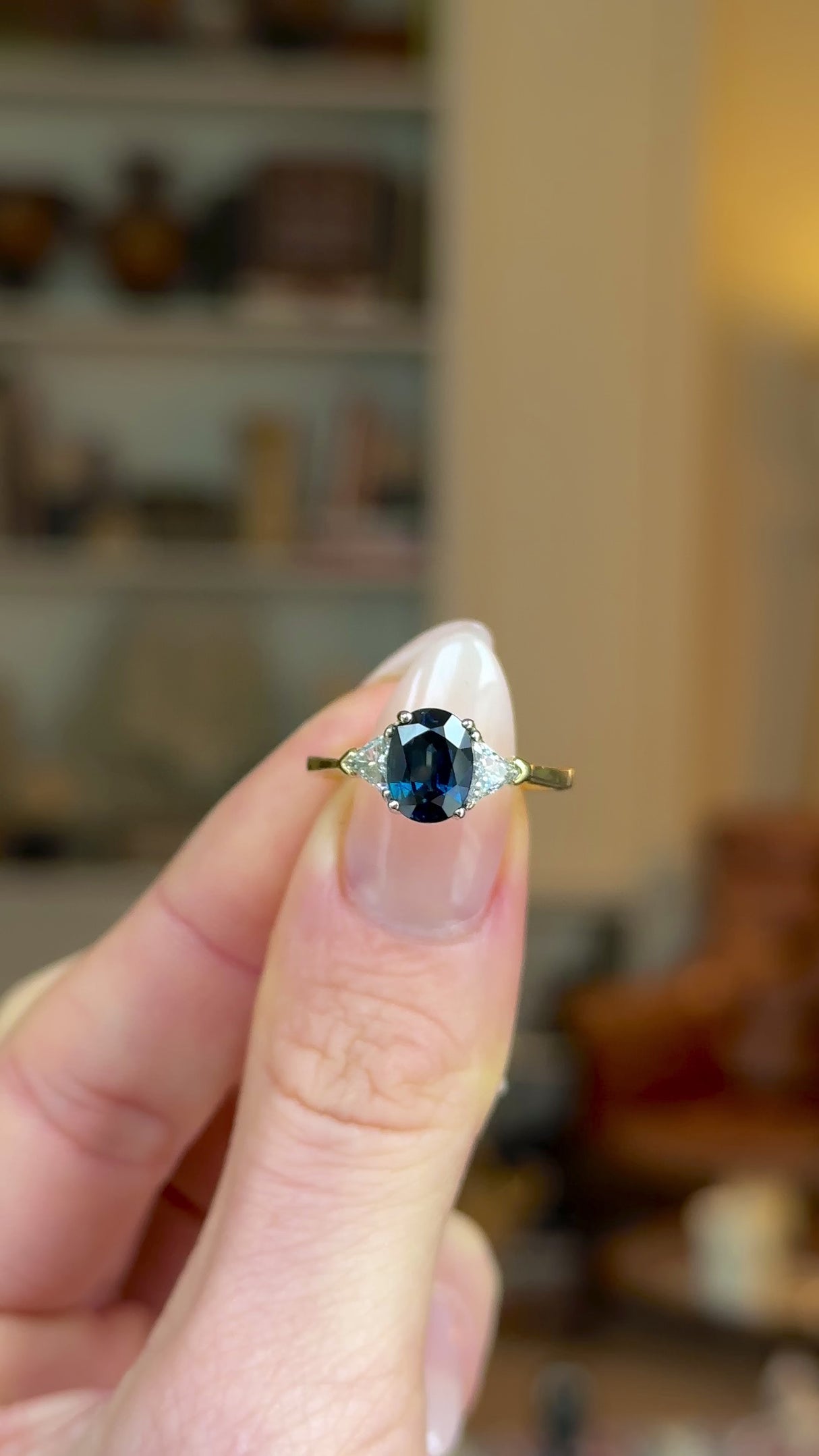 Vintage, Sapphire and Diamond Three-Stone Engagement Ring, 18ct Yellow and White Gold held in fingers and rotated to give perspective.