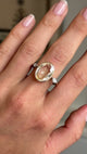 Video of a yellow gold Vintage, 1980s yellow sapphire & diamond three-stone engagement ring worn on a hand against a blurred background