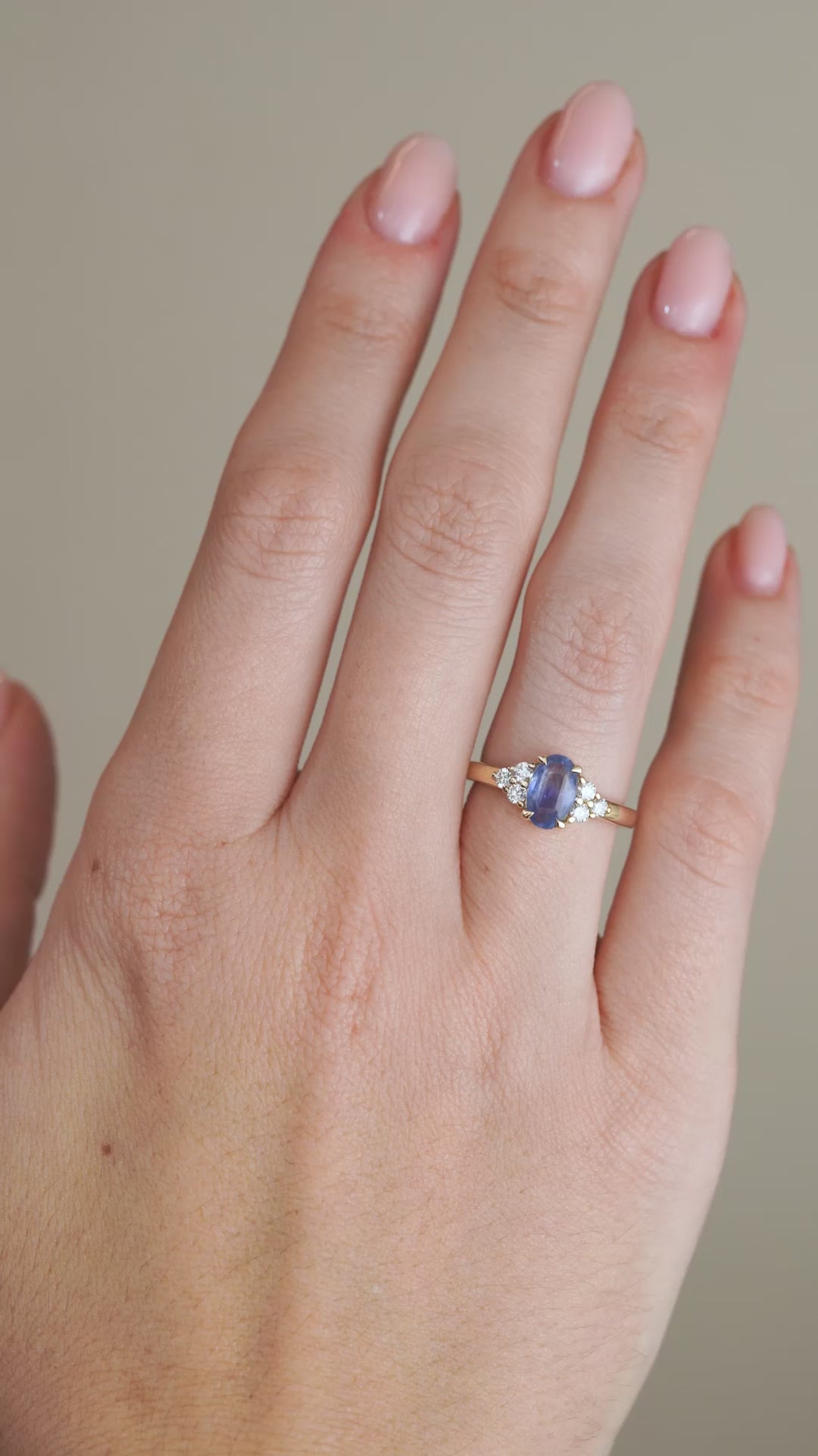 A video showing the vintage-inspired sapphire engagement ring being worn on a hand, highlighting its blue gemstone and diamond-set shoulders.