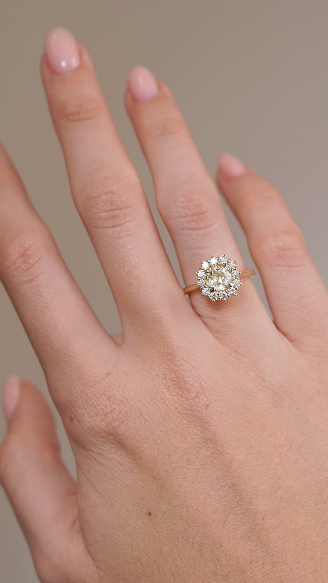 A video of the yellow diamond cluster engagement ring worn on a hand, capturing its delicate proportions and sparkling diamond halo.