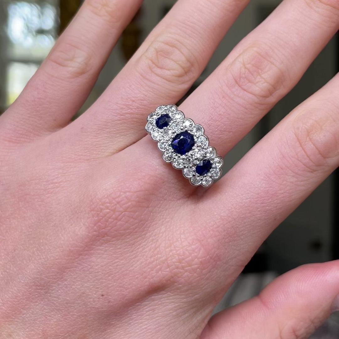 Antique sapphire and diamond triple cluster ring, worn on hand and moved around to give perspective.