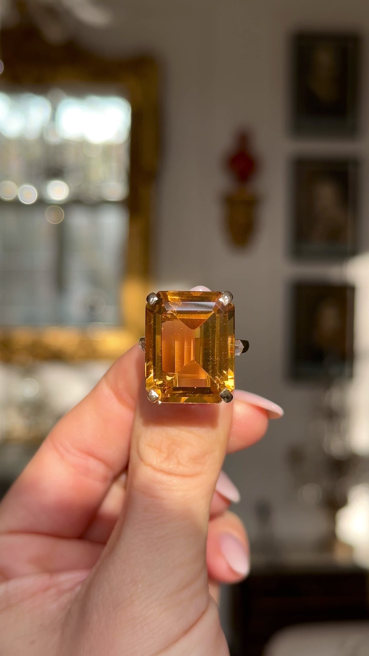 vintage cartier citrine cocktail ring held in fingers and moved around to give perspective.