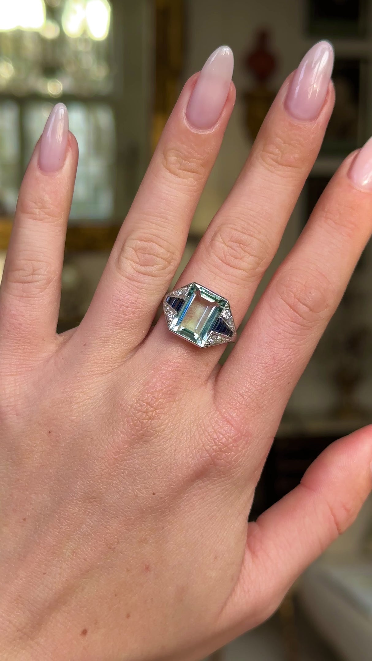 vintage aquamarine, sapphire and diamond ring worn on hand and moved around to give perspective. 