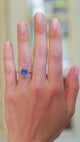 Solitaire ring worn on hand showing cornflower blue sapphire tone and natural movement.