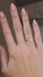 A video of a yellow sapphire solitaire engagement ring worn on a hand, capturing the gemstone's sparkle and polished yellow gold setting.