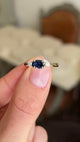 Close up video of a gold Vintage, 1960s blue sapphire & diamond three-stone engagement ring rotated slowly to show the stones from all angles