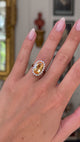 Imperial topaz and diamond cluster ring with gold band on hand and moved away from lens to give perspective