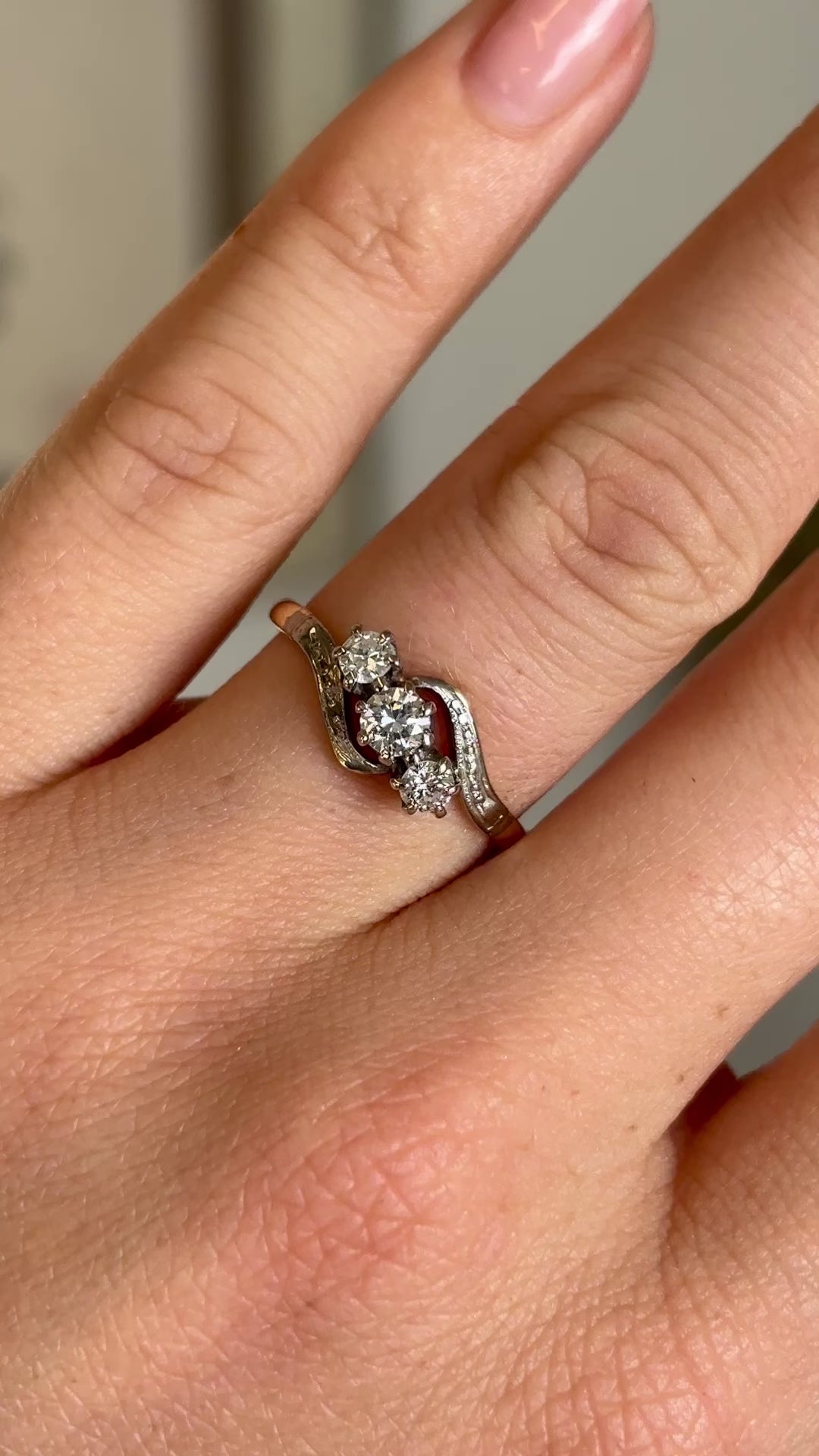 Antique, Edwardian three-stone diamond twist ring worn on hand.