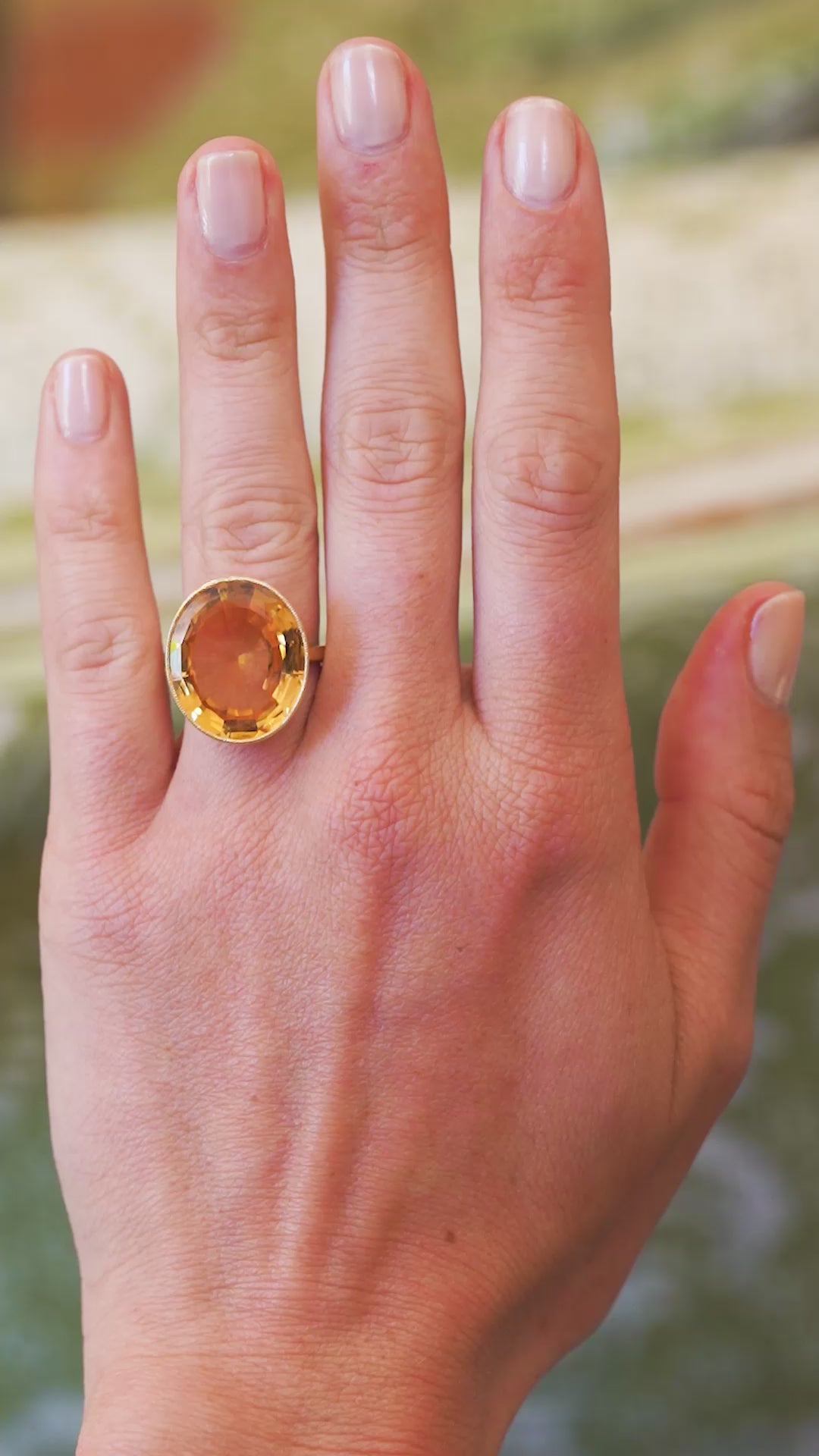 Orange topaz cocktail ring worn on hand showing warm tone and natural movement.