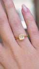 A video of an antique-inspired yellow-toned cushion-cut diamond solitaire ring in yellow gold worn on the hand.