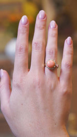 Victorian angel skin coral and diamond cluster ring worn on hand showing soft coral tone and diamond sparkle in movement.