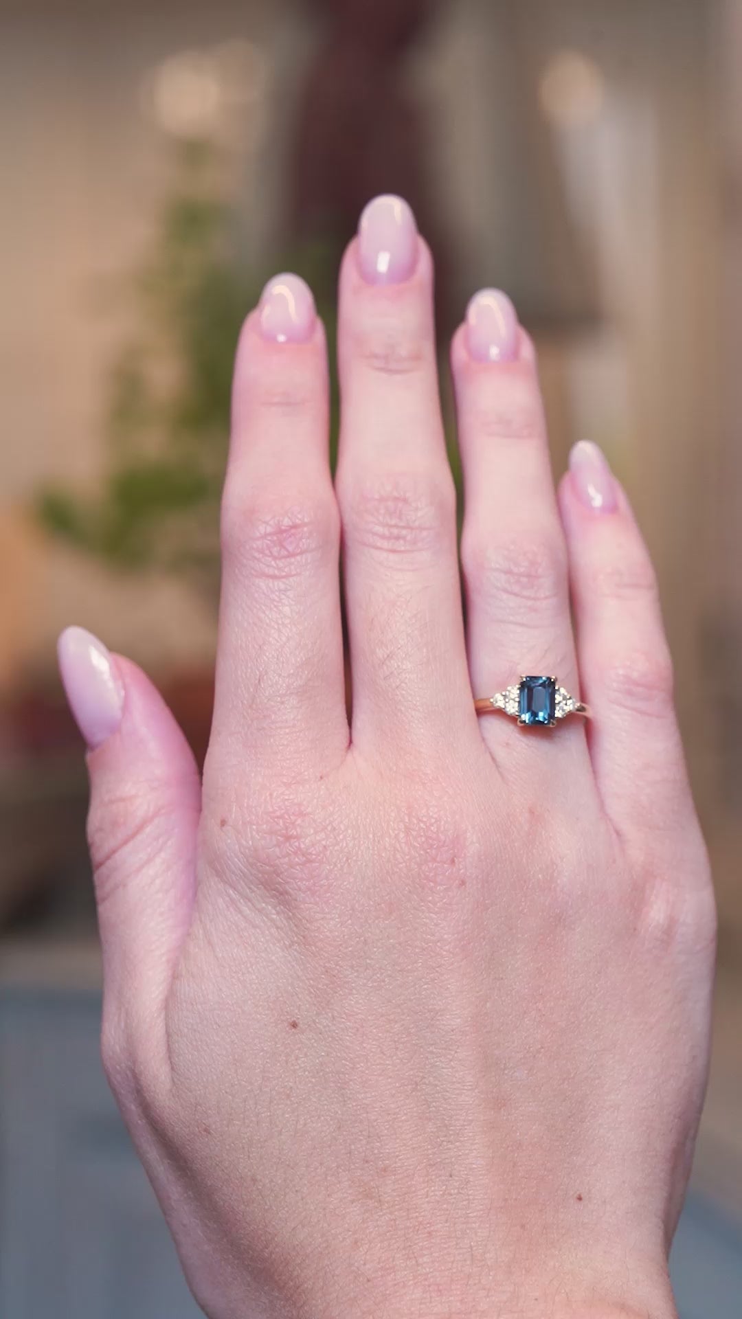 Teal sapphire and diamond cluster tre-foil engagement ring worn on hand with subtle movements.