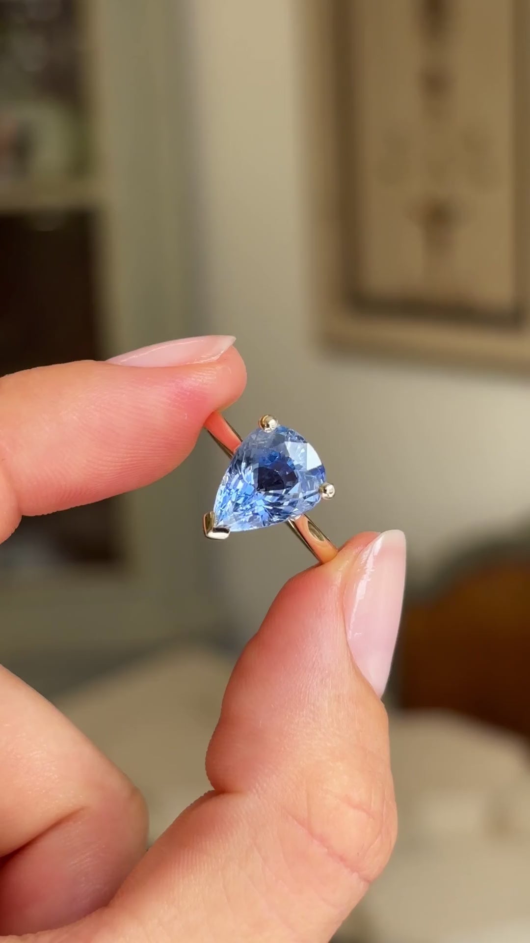 Detailed video of a vintage inspired pear-cut bluebell sapphire solitaire engagement ring, featuring a pear-shaped bluebell sapphire displayed between fingers to showcase its colour and sparkle.