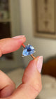 Detailed video of a vintage inspired pear-cut bluebell sapphire solitaire engagement ring, featuring a pear-shaped bluebell sapphire displayed between fingers to showcase its colour and sparkle.