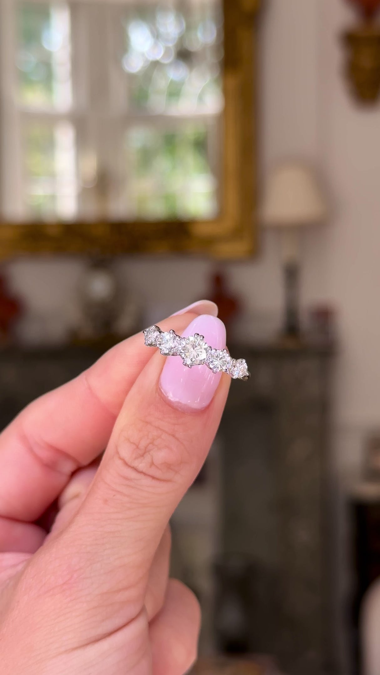 Antique five stone diamond ring held in fingers and moved around to give perspective.