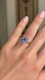 Video of a vintage inspired pear-cut bluebell sapphire solitaire engagement ring worn on hand, showcasing the sparkling bluebell sapphire and elegant yellow gold setting from multiple angles.