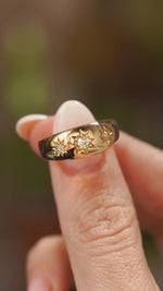 A video of Antique, Edwardian diamond three-stone gypsy ring in yellow gold held between the fingers and slowly rotated to showcase different angles