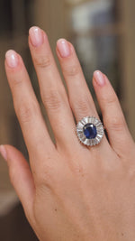 Video of a vintage blue sapphire and diamond cocktail ring worn on the hand, highlighting the sparkle of its ballerina-style cluster.