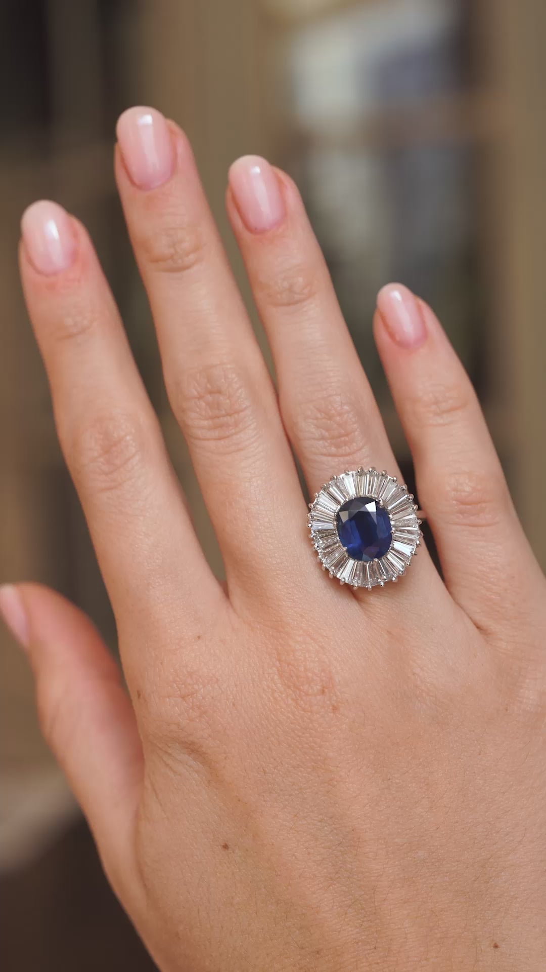 Video of a vintage blue sapphire and diamond cocktail ring worn on the hand, highlighting the sparkle of its ballerina-style cluster.