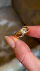 Antique, Victorian diamond solitaire gypsy ring held in fingers and slowly rotated to show the fine details 