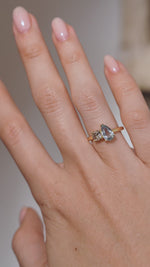 A video of the toi et moi engagement ring worn on a finger, capturing the soft blue sapphire and warm champagne diamond tones.