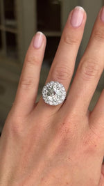 Vintage 1950s platinum diamond cluster engagement ring worn on hand, featuring approximately 4 carats of brilliant diamonds, filmed against a softly lit vintage interior backdrop to showcase exceptional sparkle and presence.
