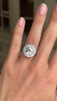 Vintage 1950s platinum diamond cluster engagement ring worn on hand, featuring approximately 4 carats of brilliant diamonds, filmed against a softly lit vintage interior backdrop to showcase exceptional sparkle and presence.