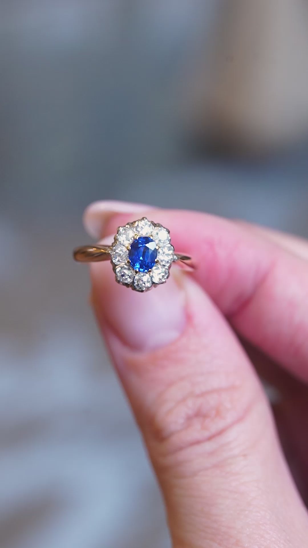 Close detail video of antique Belle Époque sapphire and diamond cluster engagement ring with ornate setting.