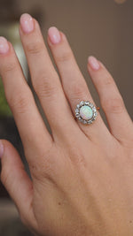 Video of the Edwardian opal cabochon cluster ring on the hand, capturing the gemstone’s shifting rainbow play of colour.
