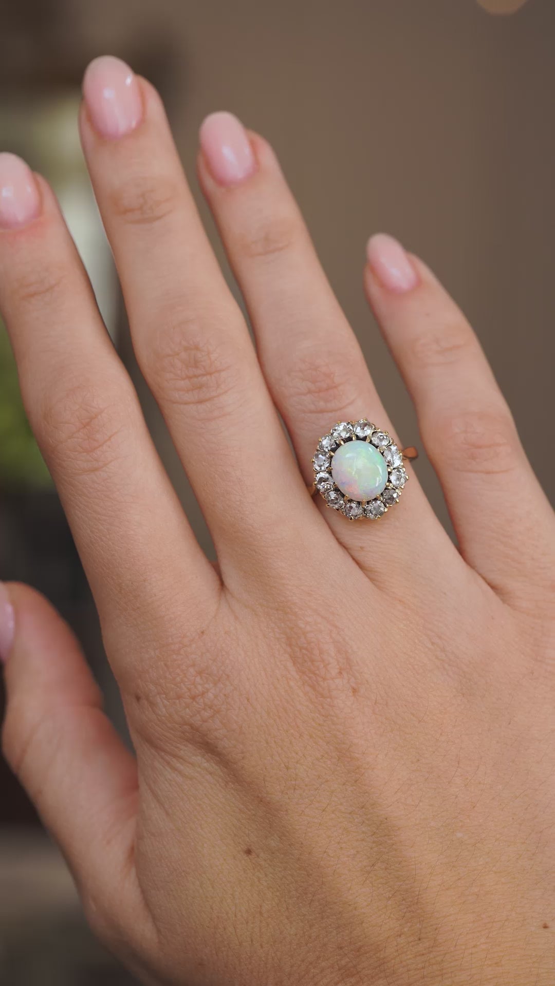 Video of the Edwardian opal cabochon cluster ring on the hand, capturing the gemstone’s shifting rainbow play of colour.