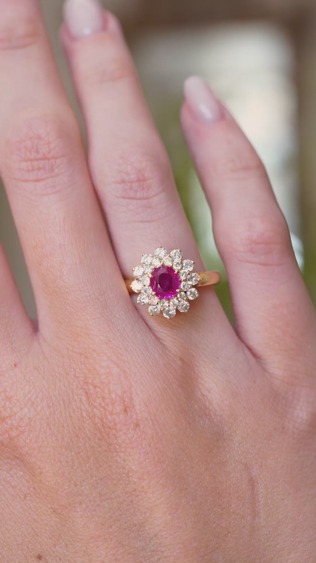 A video showing a vintage 1980s Burmese ruby and diamond cluster ring worn on the finger with a wider view of the hand.