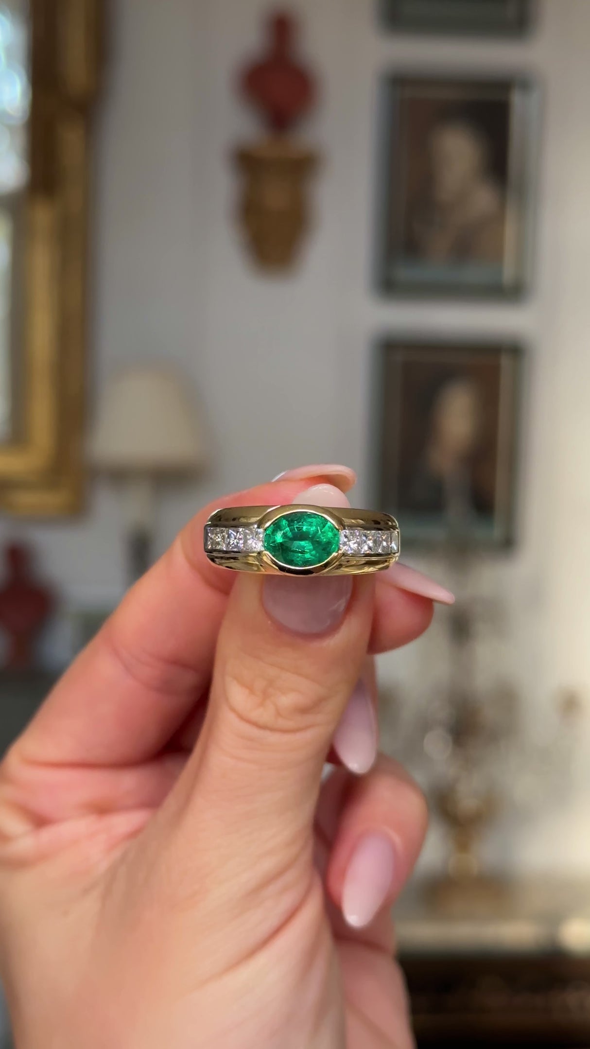 Vintage emerald and diamond band held in fingers and moved around to give perspective.