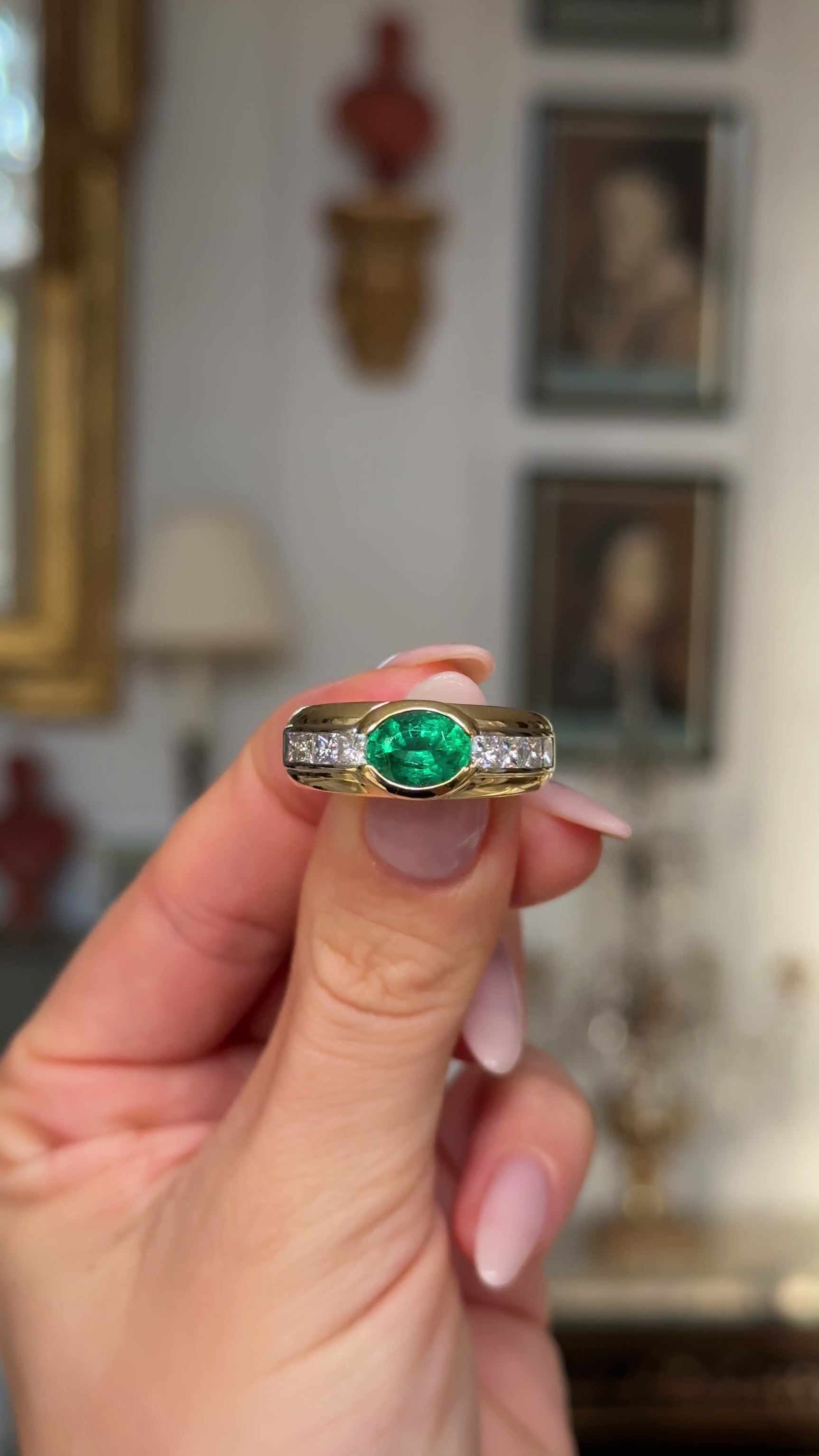 Vintage emerald and diamond band held in fingers and moved around to give perspective.