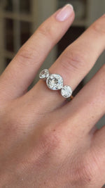 Antique Edwardian old-cut diamond three-stone engagement ring featuring three old-cut diamonds in a classic trilogy setting, displayed on a hand.