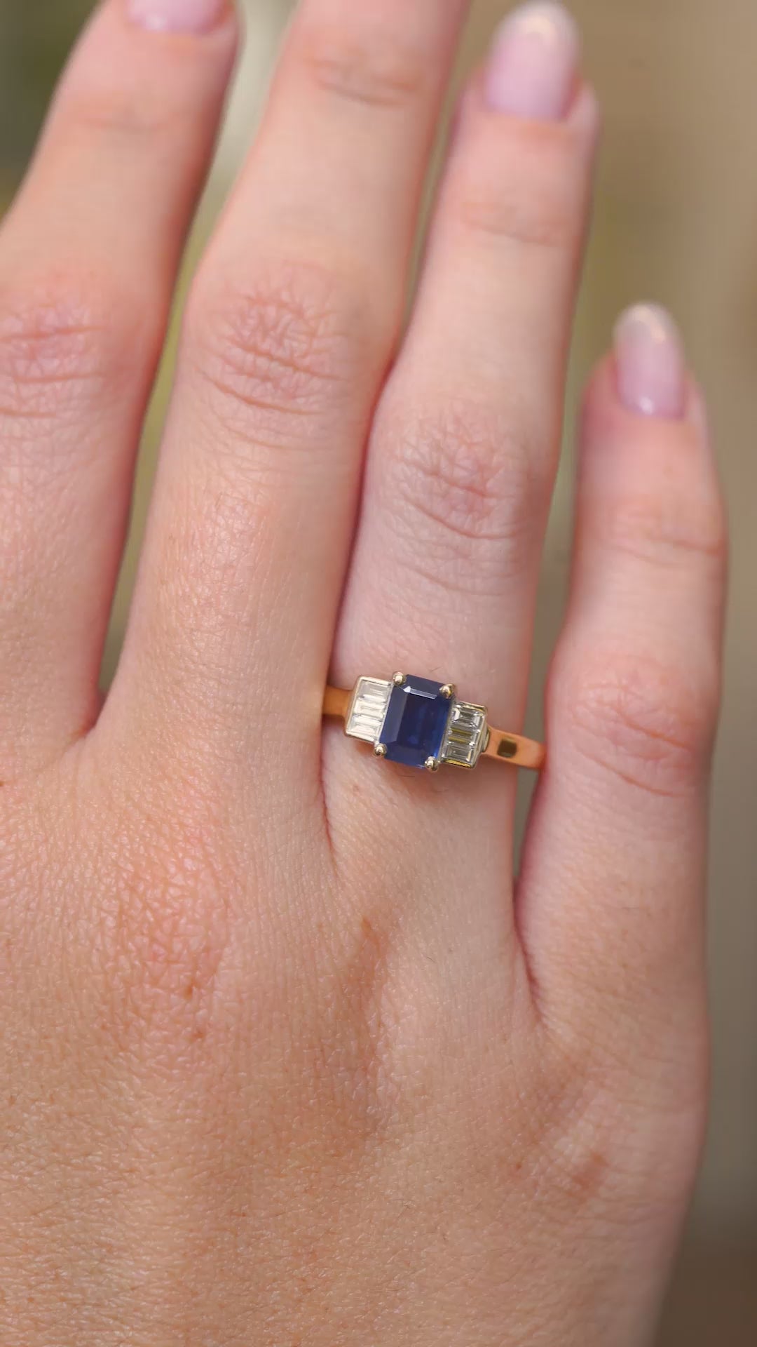 A video of vintage 1960s sapphire and diamond engagement ring worn on the hand.
