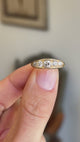 Antique Victorian old-mine cut diamond five-stone engagement ring showcasing five graduated old-mine cut diamonds, held by hand to highlight the setting and craftsmanship.