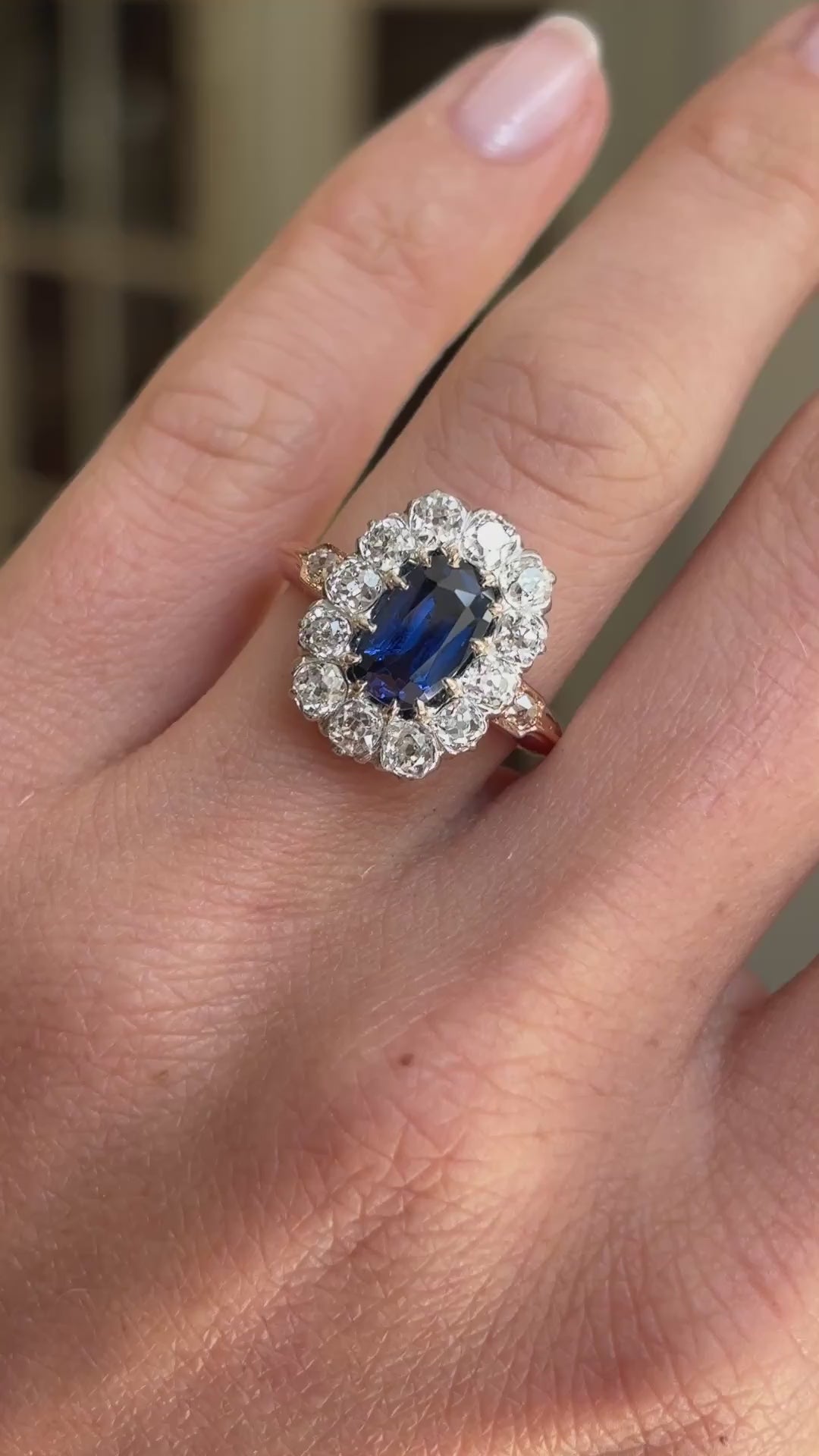 Video of an antique Jugendstil royal-blue sapphire and diamond cluster ring worn on hand, showcasing the vivid royal-blue sapphire and sparkling diamond cluster setting.