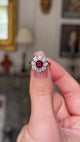 antique ruby and diamond cluster ring held and rotated. shot with an antiquated bokeh background