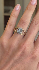 Antique Georgian forget-me-not cameo cluster ring featuring a hand-carved forget-me-not cameo in a decorative cluster setting, displayed on a hand.
