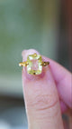 Detailed view of antique Victorian yellow sapphire solitaire ring showing ornate gold setting between fingers.