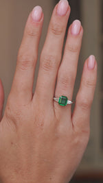 Video showcasing the vintage emerald and diamond engagement ring on the hand as its stones reflect the light.