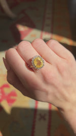 A video of a yellow gold yellow sapphire cluster engagement ring worn on the hand and rotated.