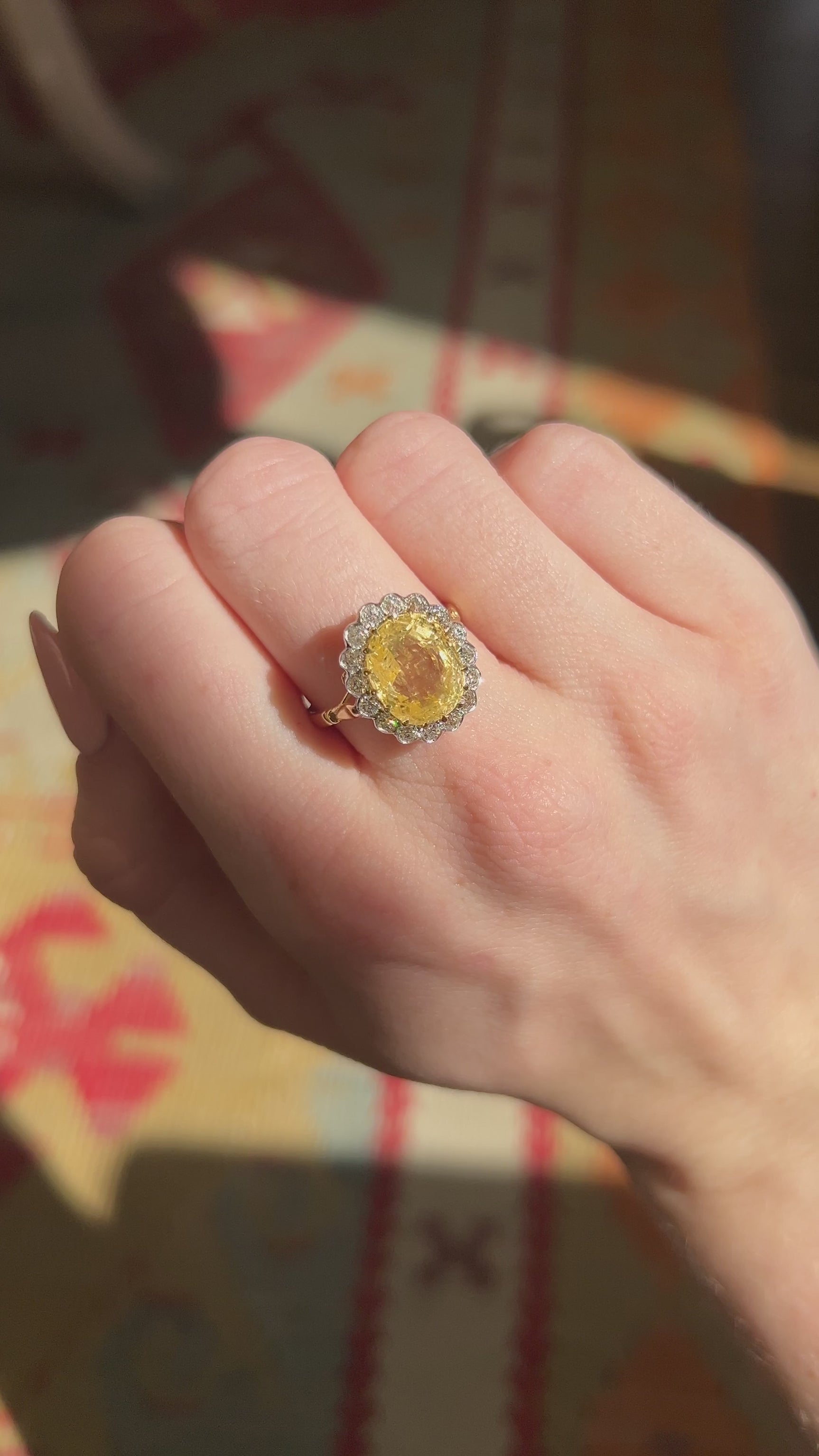 A video of a yellow gold yellow sapphire cluster engagement ring worn on the hand and rotated.