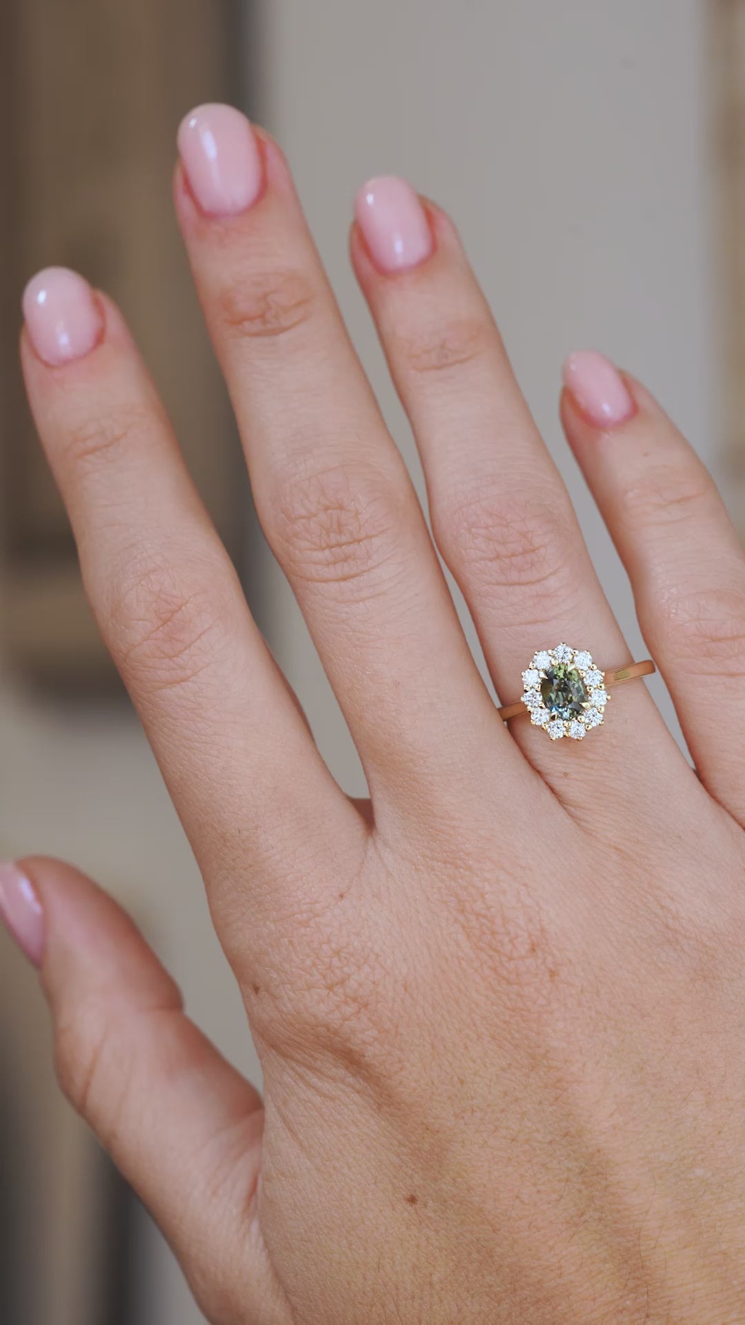 Video of a green sapphire and diamond halo ring on the hand, showing its scale, colour and antique-inspired proportions.